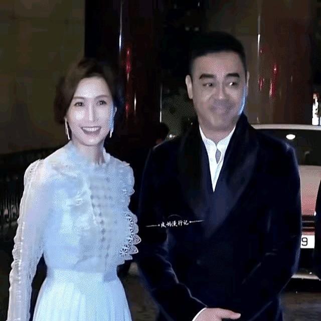 刘青云想牵老婆手落了空。等郭蔼明伸手时，他又正盯着镜头。这对夫妻在闪光灯前，总透着一股真实的拘谨。银