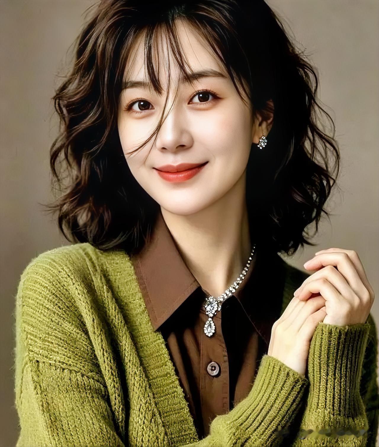 橄榄绿针织柔化轮廓，卷发轻拂颈间，温婉气质在光影中静静流淌。