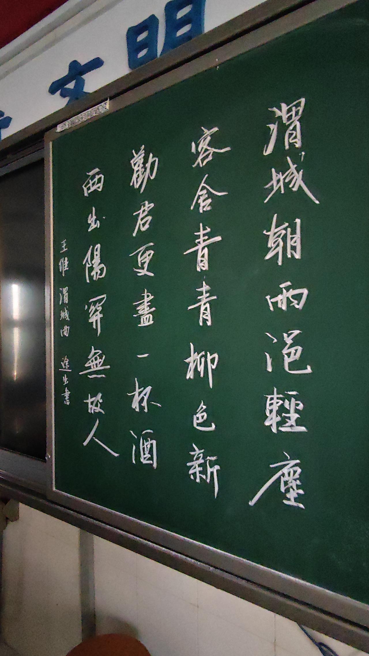 准备写春联了，先在黑板上用粉笔练一练字。书法