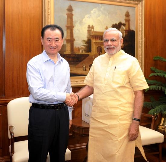 莫迪穿着金色服装和王健林握手，穿着粉色衣服和马云握手，他穿衣打扮挺休闲的。