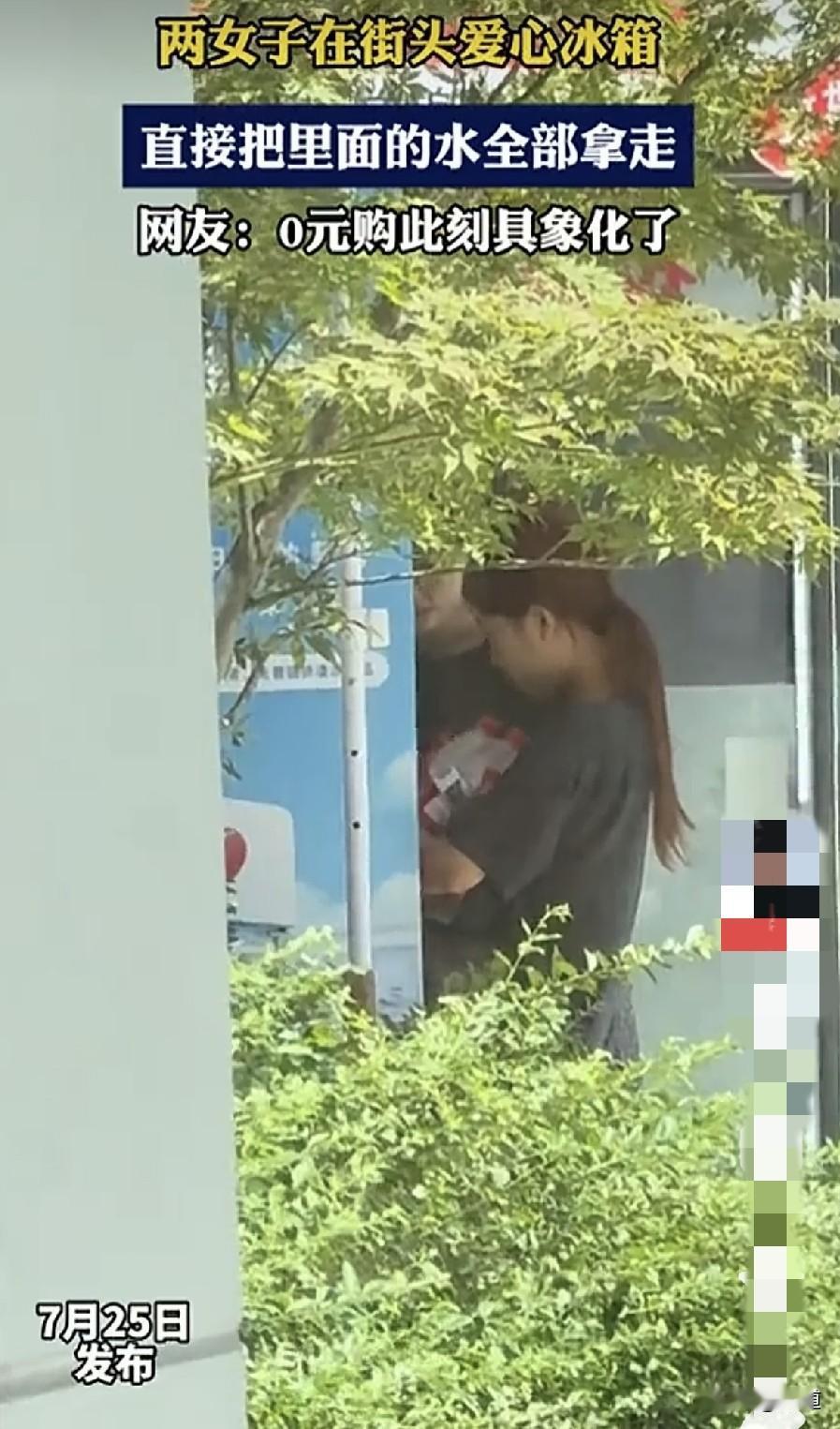 俩女子走在大街上，忽然发现爱心冰箱里的水可以免费白拿，这可把她们俩给乐坏了。赶