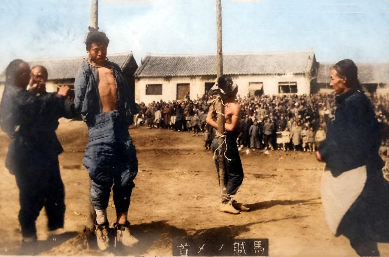 清末东北，一处民居前的空地上，两名男子被绳索紧紧绑缚于木柱之上。其中一人双脚悬空