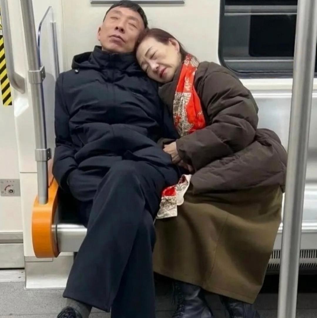 地铁偶遇这一幕，看完瞬间破防！一对老两口裹着厚棉袄，靠在一起沉沉睡着了，看