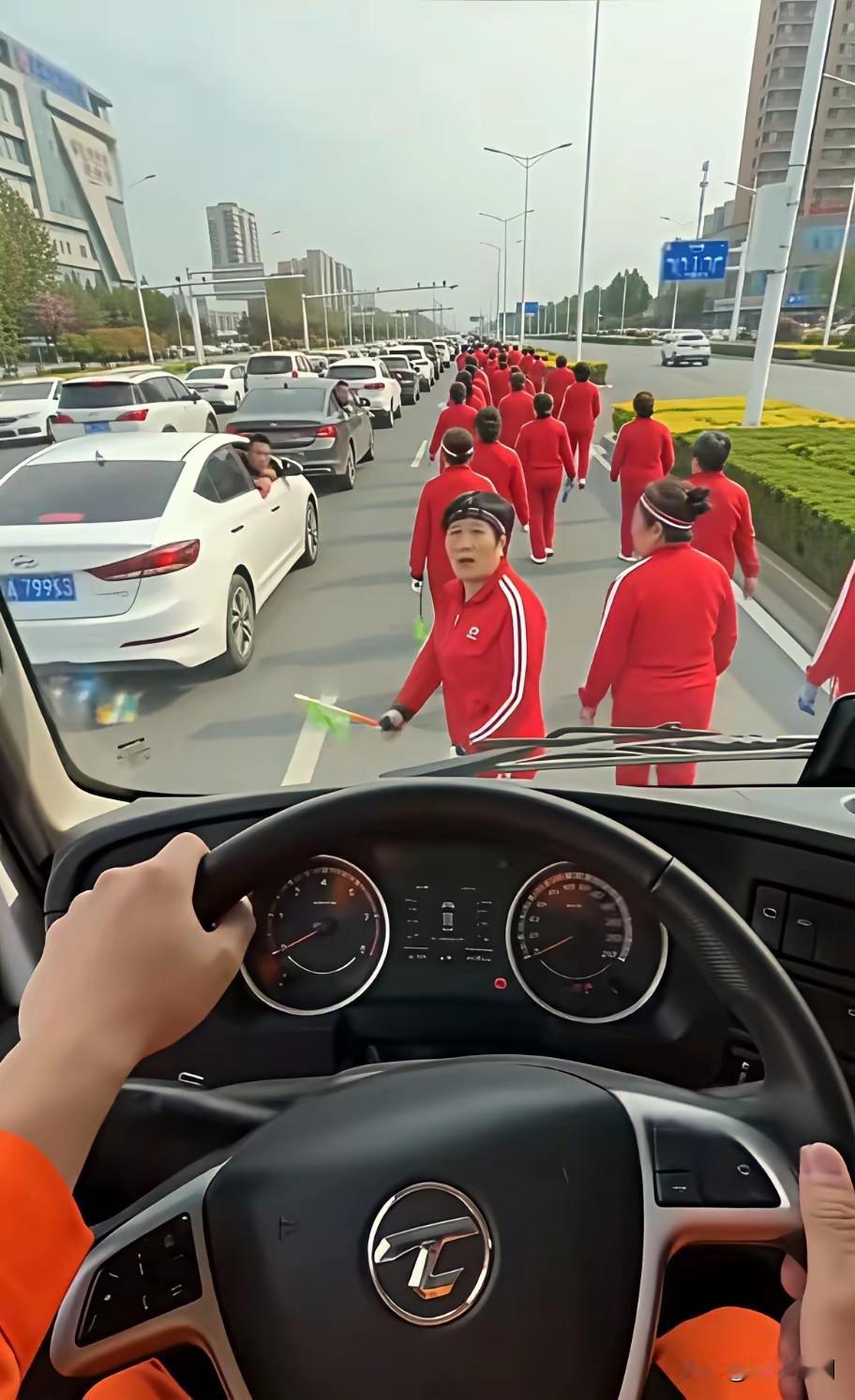 这个师傅一系列操作看了好像没有违和感，没毛病！洒水车要工作，但整个道路被老年暴走
