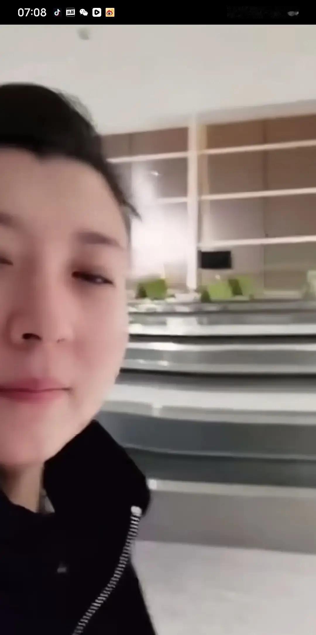 闫学晶一个人站在商场门口，对着空气说话还笑出声，路人举着手机拍她，她也没躲。