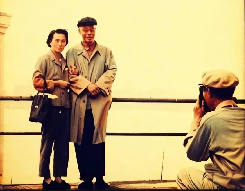 60年代，溥仪与妻子李淑贤站在大桥上拍照时的一幕，李淑贤亲密的挽着溥仪的胳膊夫妻