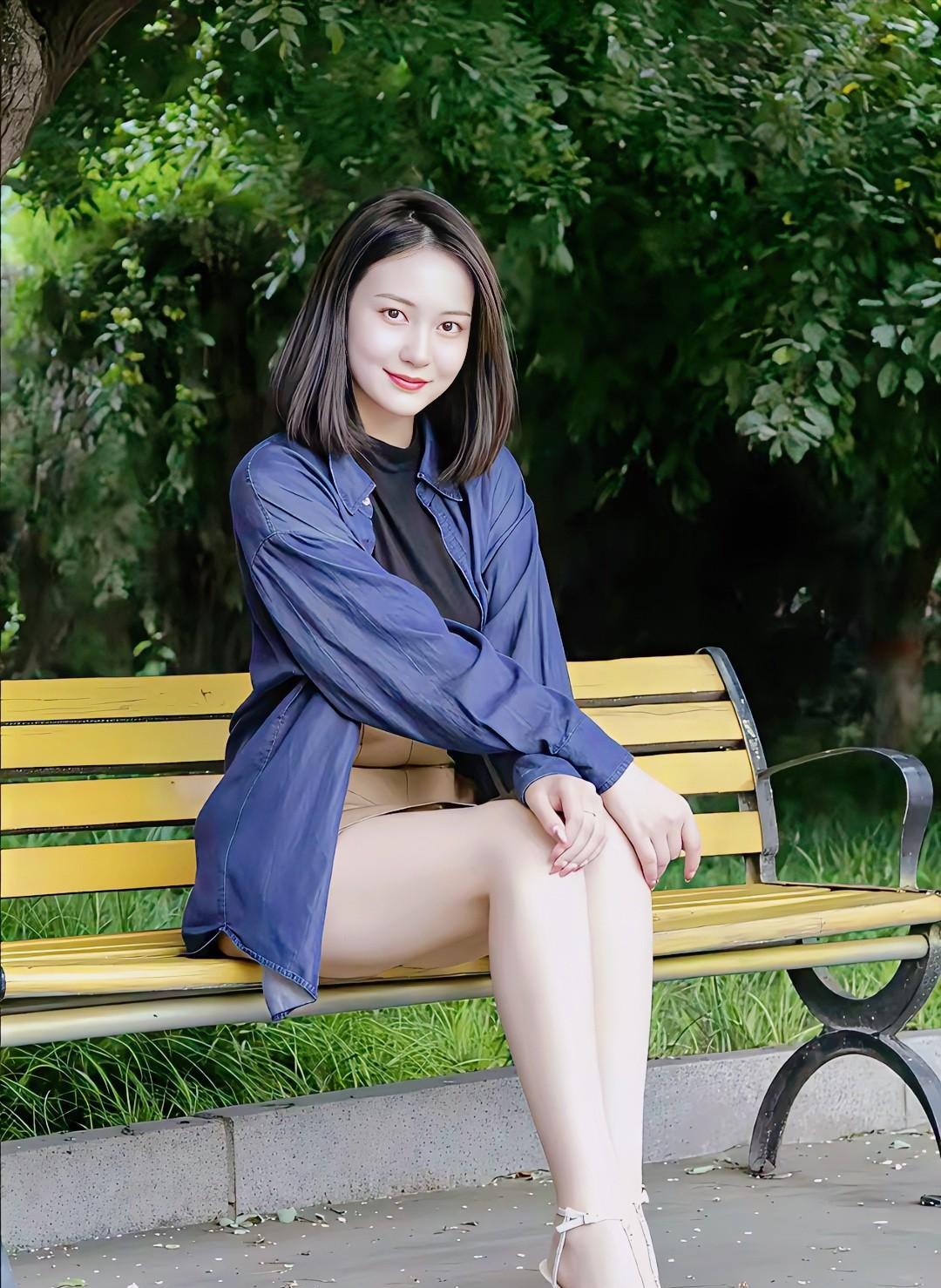 绿树阴中倚长椅，轻纱薄衫映春光。