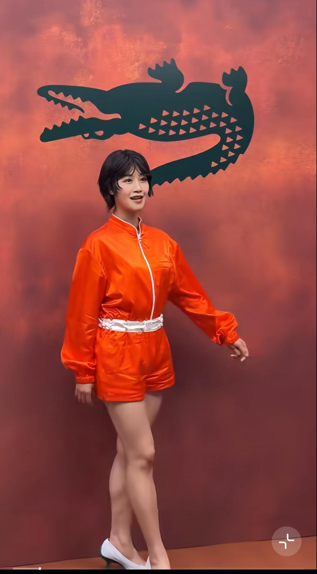 蓝盈莹巴黎秀场一抹亮，一身亮眼的橙色缎面运动套装，搭配白色腰边，短发造型清爽十足