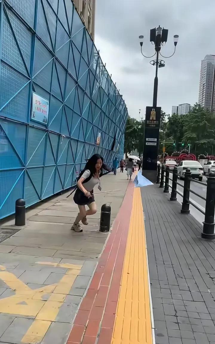重庆解放碑附近一大厦施工脚手架坍塌，一名导游小姐姐正好路过，反应飞快！墙体刚倾斜