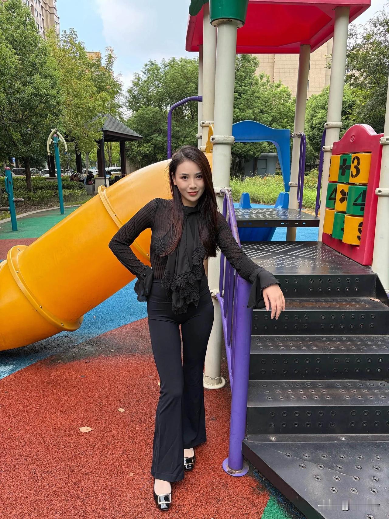 这位美女站在游乐场里拍照呢。