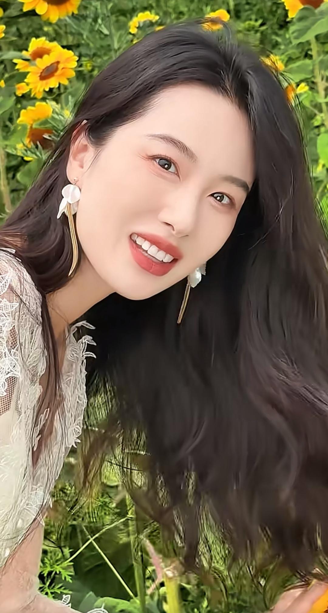 在向日葵田中，微笑的少女与自然融为一体，宛如一幅美丽的画卷。
