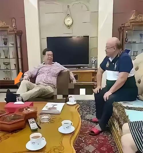 曹德旺对面正襟危坐的这位男士，一看发型就知道地位不低啊，曹总把脚翘得那么高，是不