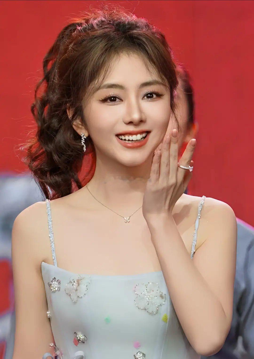 百花迎春晚会录制现场，谭松韵身着蓝色吊带礼裙亮相，高马尾卷发加持，肌肤莹润，美得