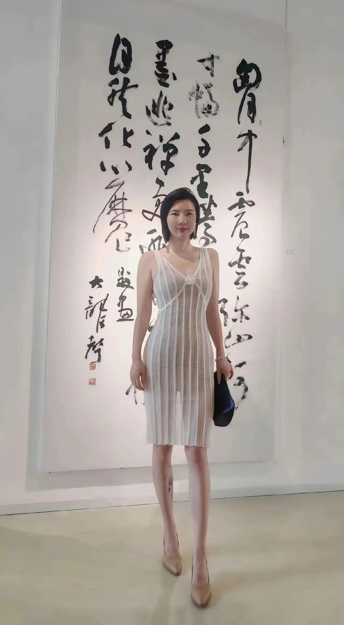 到底是想看人，还是想看她身后的字？我是一个书法爱好者其实很想看那挂在墙上的