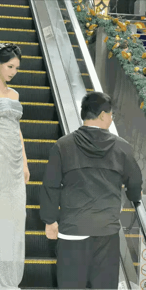 老实的男人到那里都有人欺负，这不大哥去超市购物，上扶梯之中，前面一个穿旗袍的美女
