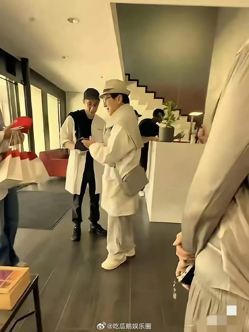 成龙与房祖名父子在瑞士被偶，二人都穿着白色的衣服，房祖名腿细得让人心疼，像生病了