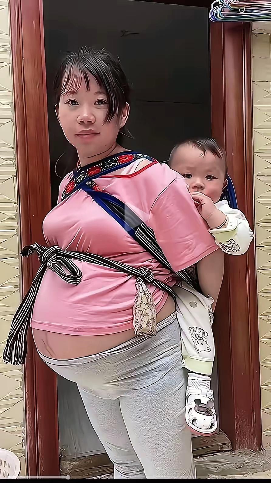 刷到个视频真让人心揪！孕妇肚子大得快临盆了，后背还背着个没学会跑的娃，看穿着家境