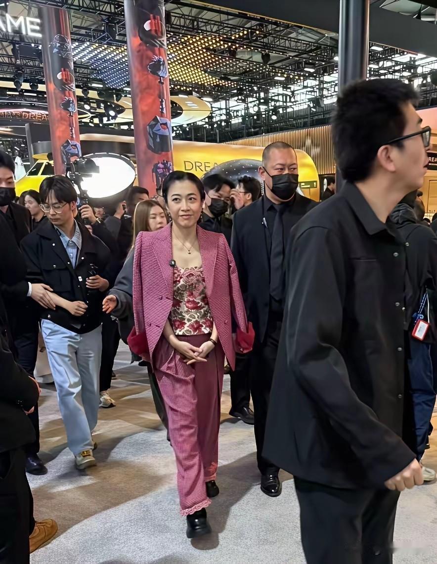 刘銮雄妻子甘比现身上海科技展，一身造型引热议。镜头下，甘比身着一身粉色印花长款套