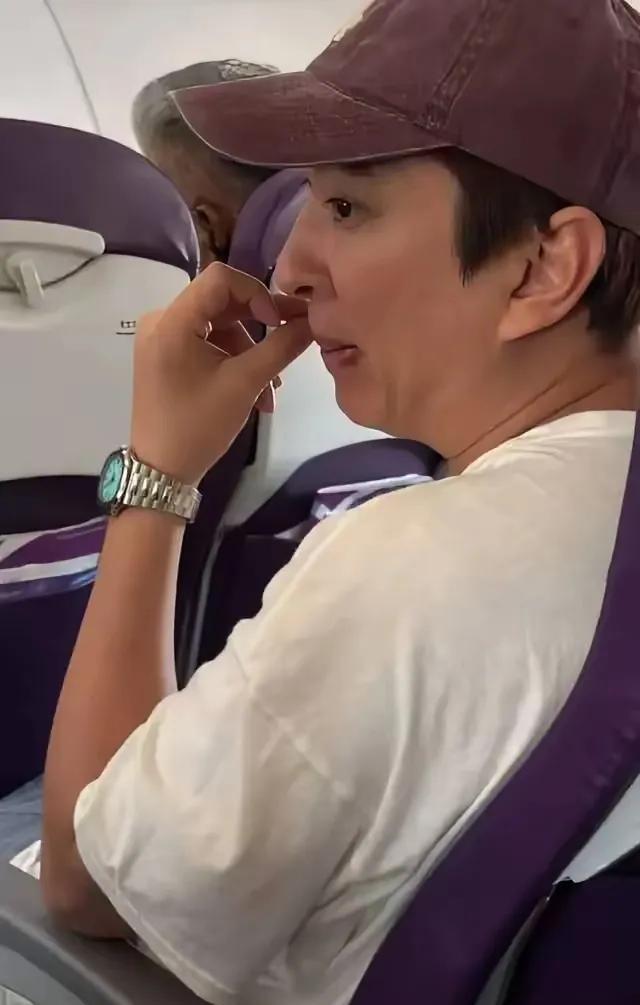 网友在日本飞往香港的航班经济舱偶遇王思聪，其蜷缩于狭小座位，一反常态选择经济舱，