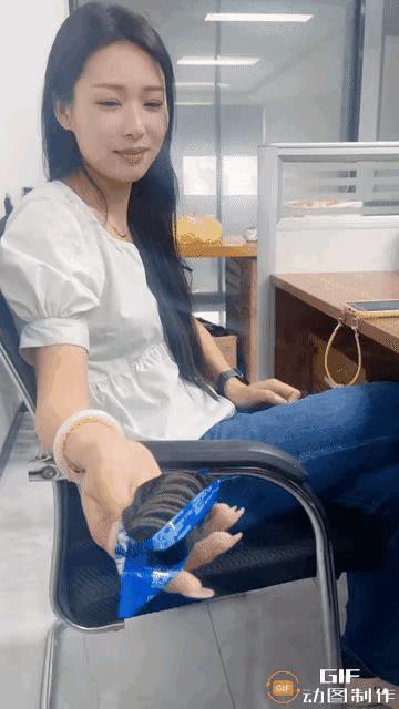 看伸过来的这只大手，就是个男同事。女孩拿出一包夹心饼干，撕开之后，想分给男同事几
