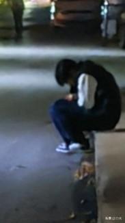 这大夜小区路灯下的一学生，在干嘛呢？走近后果然是在看手机，很投入，水泥地上也不怕