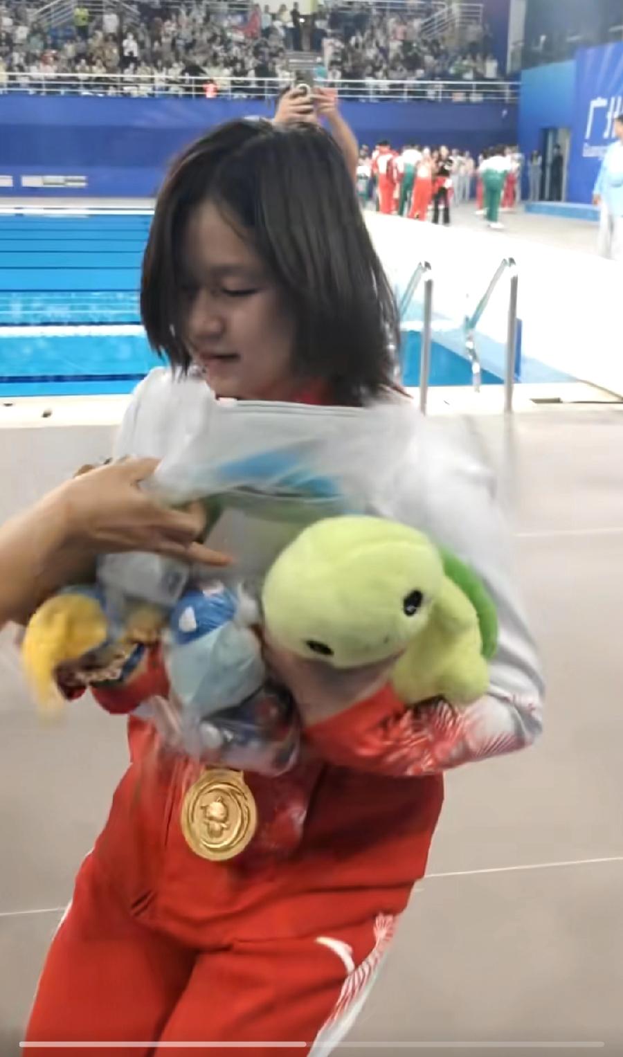 全红婵，人长大了，心还没长大，还是这么爱布娃娃！全运会现场，观众抛送全红婵布娃娃