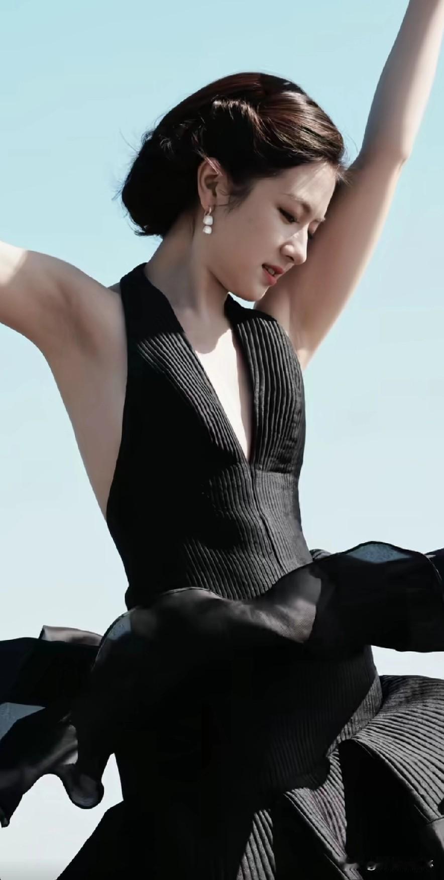 优雅黑裙舞者，在蓝天背景下翩翩起舞。——李兰迪