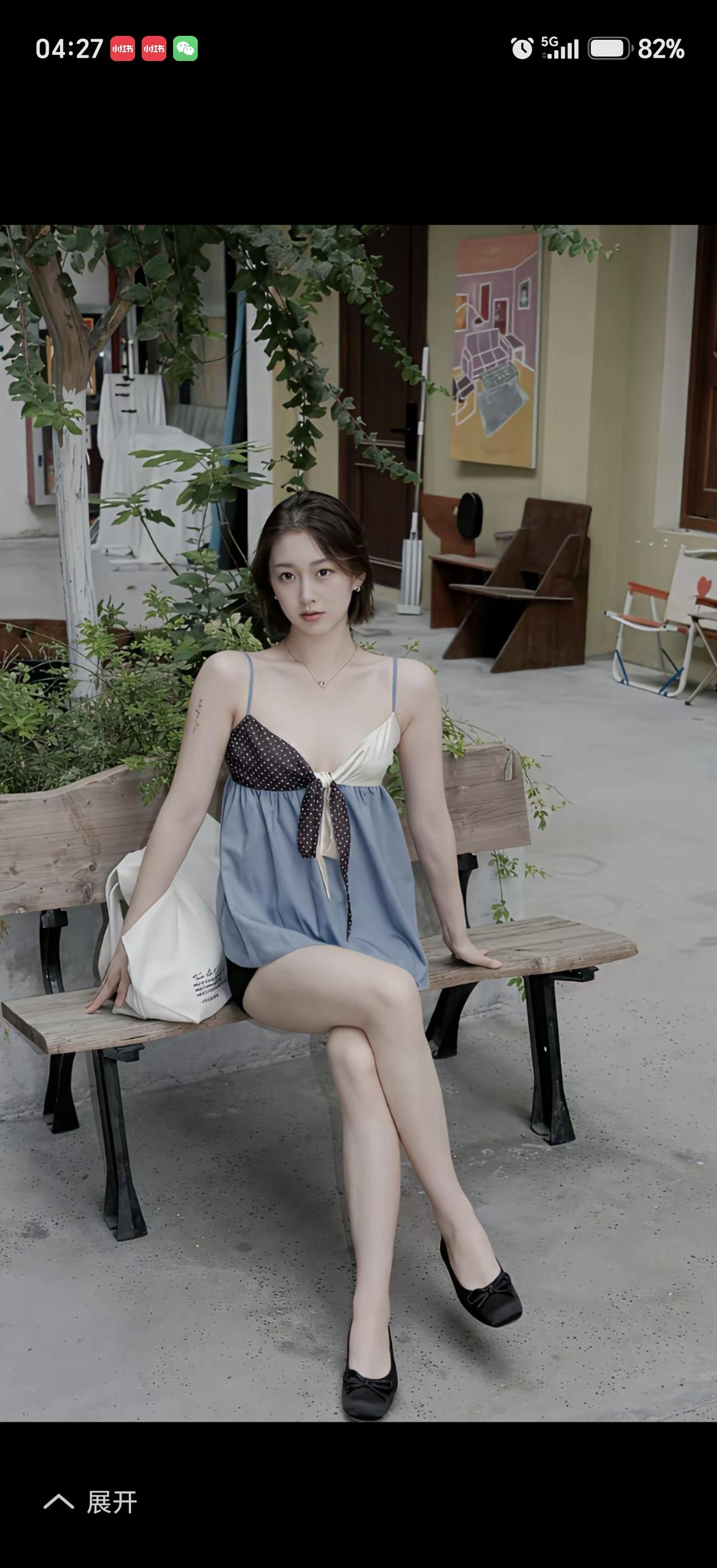一个女孩坐在长椅上，背景是绿植。