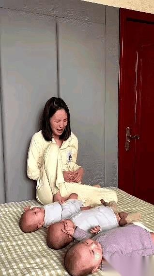 床上，三个娃跟商量好了似的，一个接一个开始哼唧。年轻妈妈的脑袋“嗡”一下，抱着