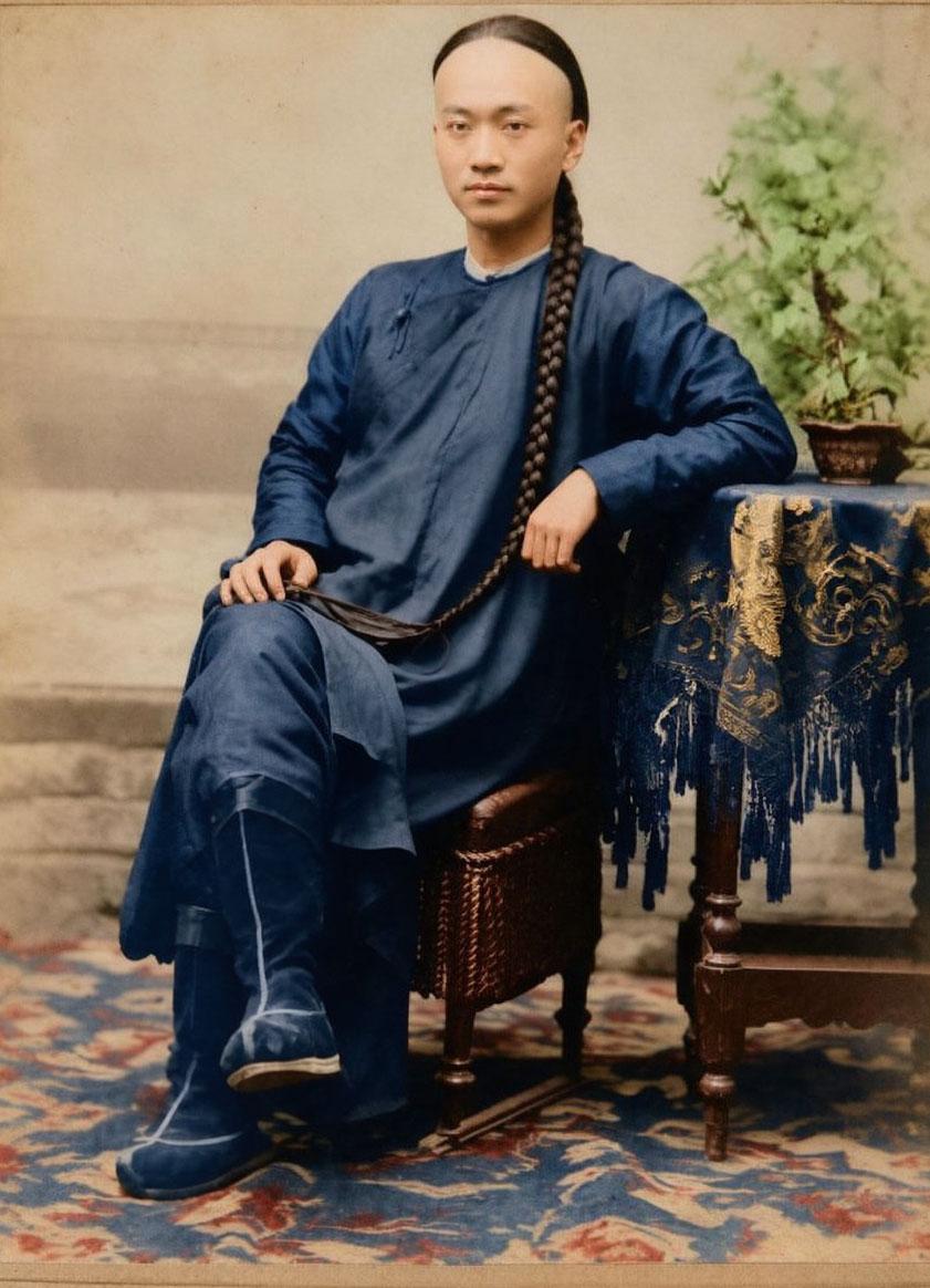 1903年7月，一名年轻男子在天津租界“比田胜写真馆”拍摄的肖像照。男子长辫垂胸