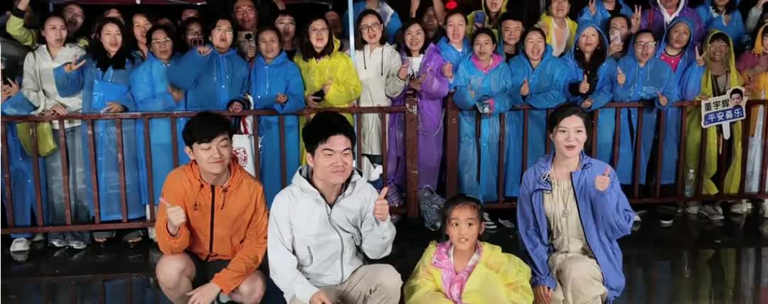 昨天晚上下播后董宇辉出来和大家合影。一个勇敢的小女孩在妈妈的鼓励下手拿着