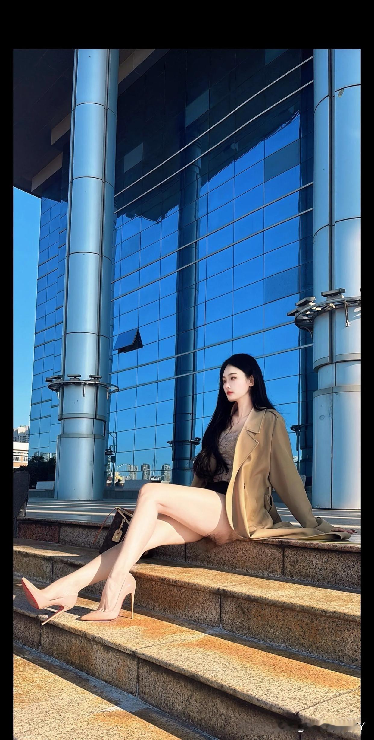 都市时尚女郎，优雅坐在现代建筑前，高跟鞋与长外套相得益彰。美女美女人像群