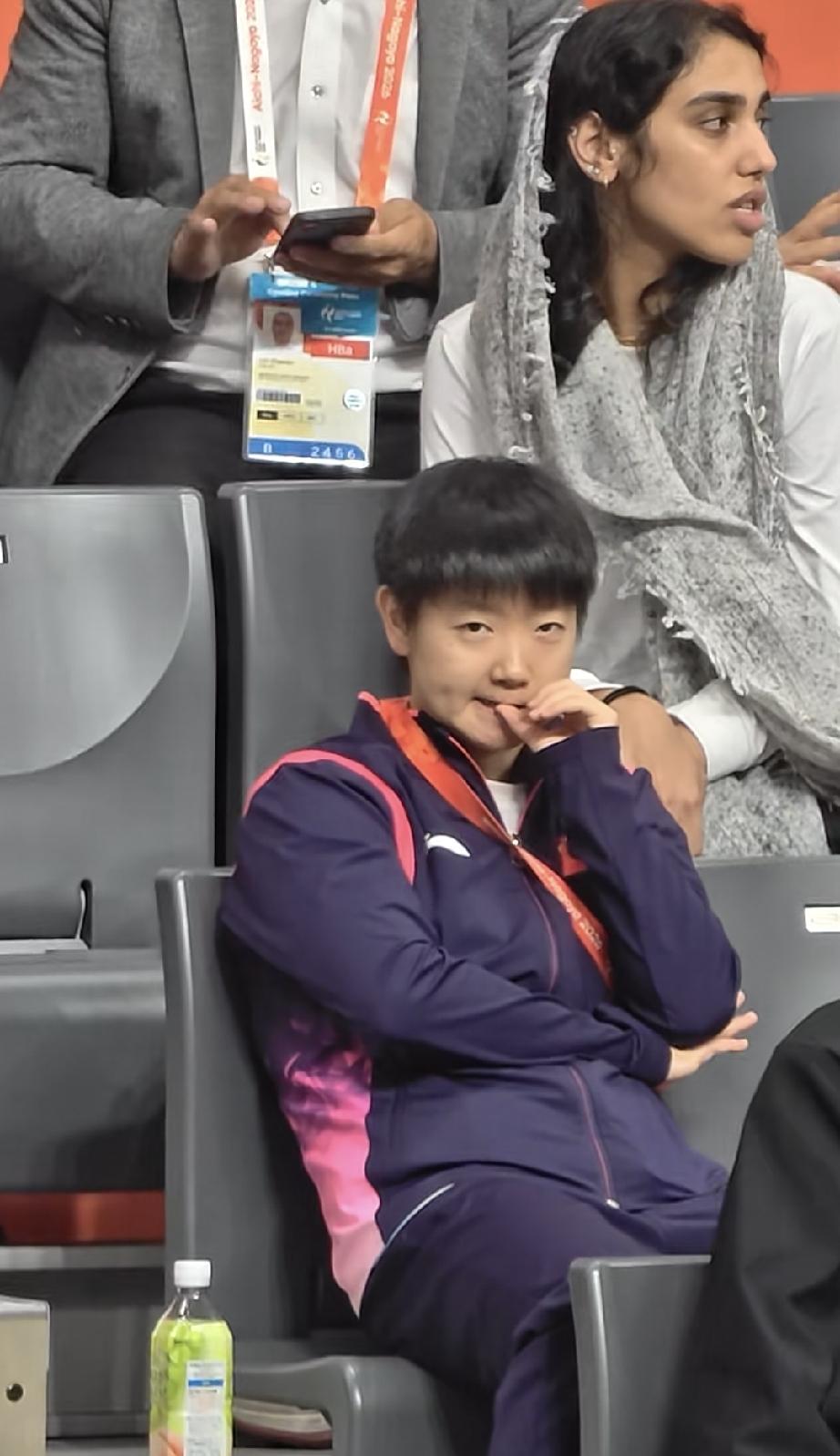 哈哈，这扣手手的动作和表情，太像十多岁的外甥女了。莎莎观众席坐着看女双。坐下后