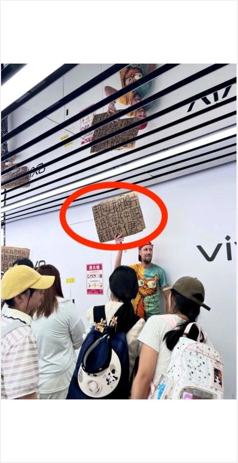 “请购买我拍的照片，支持我穿越中国的旅程，随便给”。长沙街头，一个老外举着硬纸板
