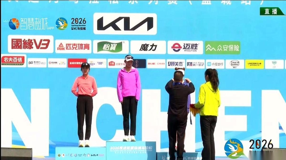 盐城马拉松的终点线，那根红色的冲刺带，在风里绷得笔直。一个身影从赛道拐角冲了出