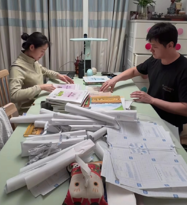 王媛可晒出自己和老公大晚上熬夜给俩儿子包书皮的视频视频里她手速极快，包完一本又