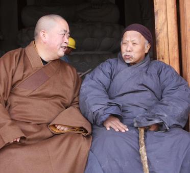 这是少林寺前方丈释永信与少林寺里的一位得道高僧坐在佛殿的门槛上侃侃而谈。释永信对