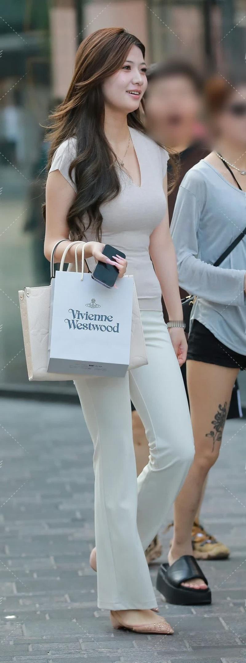 浅杏V领衫衬出柔婉气质，米白微喇裤优化身形比例，柔色搭配尽显温婉质感浅杏V领上