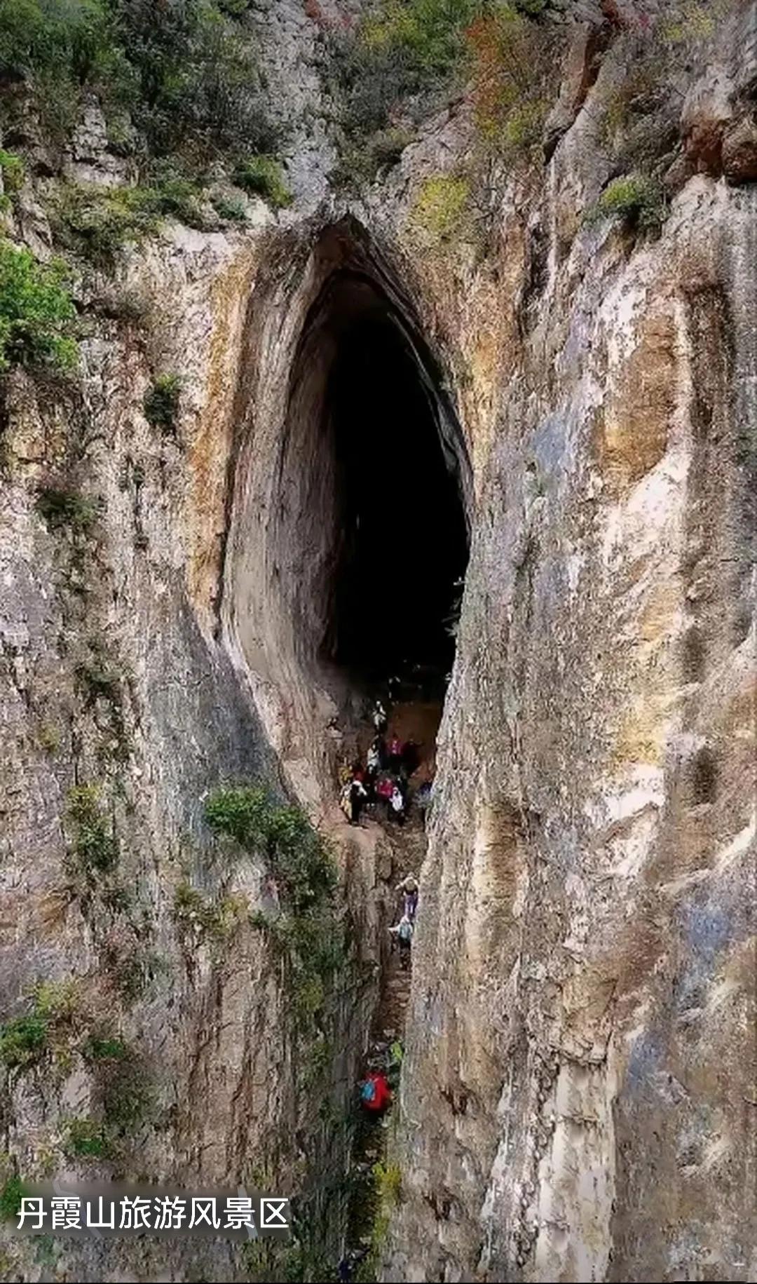 这是广东韶关丹霞山旅游风景区的著名景点，镇山之宝。很多游客从狭小的石级爬上去，在