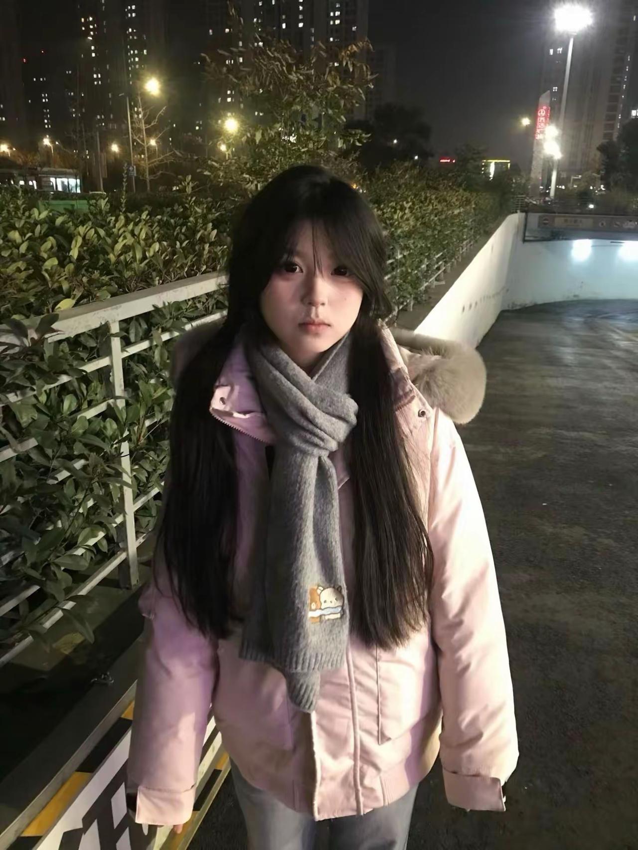 夜色裹着冬的凉意，粉粉的羽绒服配着灰色围巾，把冷风吹来的寒意都挡在外面，黑长直的