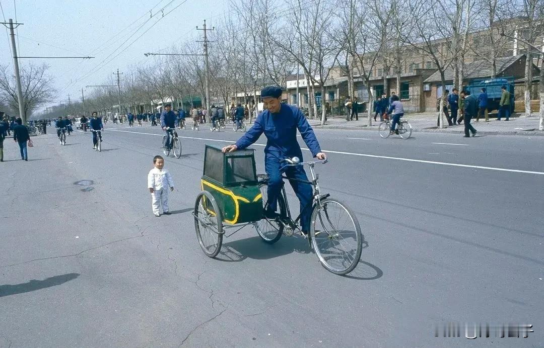 这样的童车，放如今很多人应该说不安全了吧？1984年北京街头一幕。
