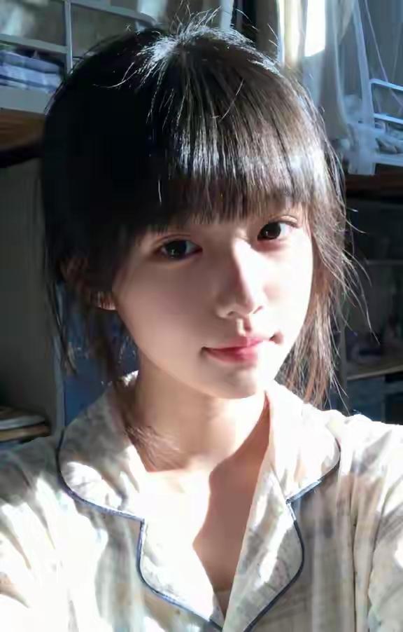 窗帘漏进来的光刚好裹住发梢，睡衣领边的蓝线沾了点懒意。没梳顺的碎发翘着，这分钟的