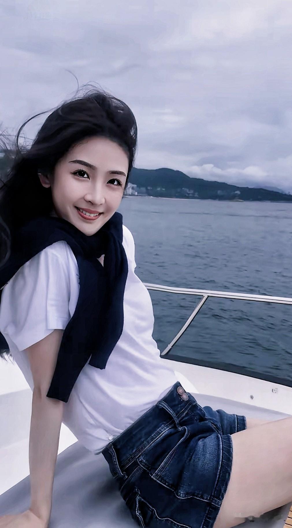 海边美女在船上微笑，风景美如画。分享一张随手拍分享你的随手拍晒一张海边最美