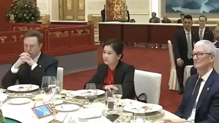 很多人好奇坐在马斯克和库克中间的女人是谁，她叫周群飞，1970年出生，湖南湘乡人