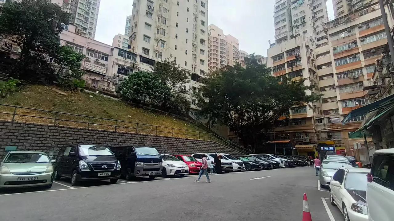 香港旧区的模样，老旧楼房下停车场的车子一字排开，一般都整洁不蒙尘，因为城中香港九