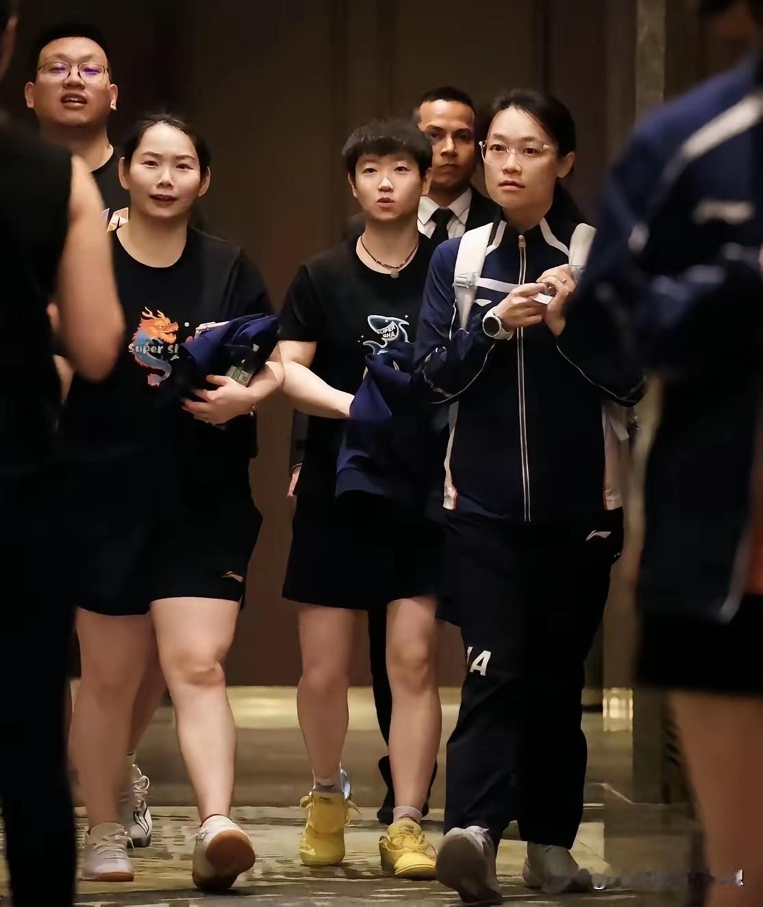 这是莎莎“创业五人组”下训时的情景。邱导在前，替莎莎推着行李箱佳佳和队医