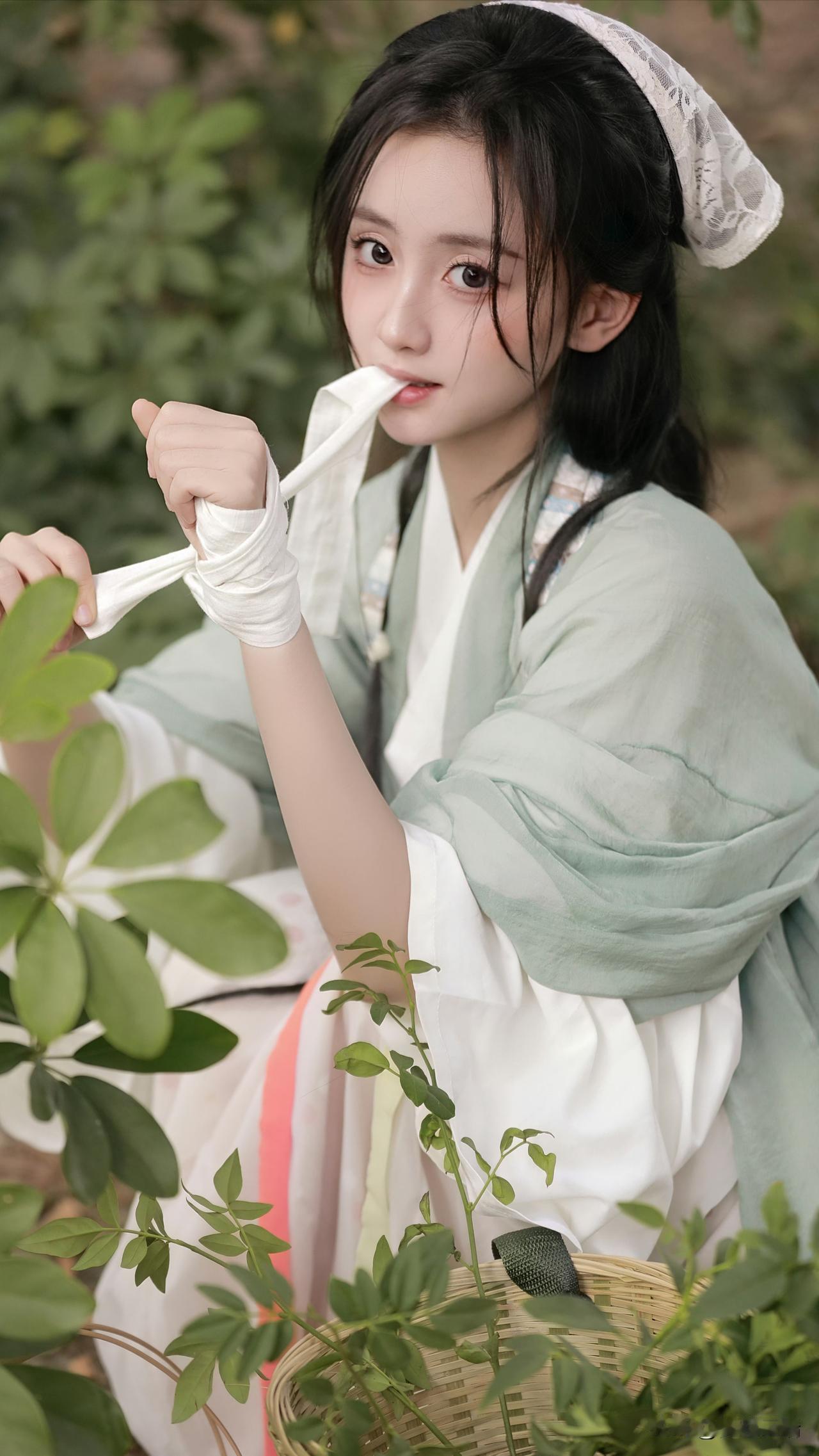 绿衣少女在花丛中，手拿白帕，清新自然，宛如古代仕女图。