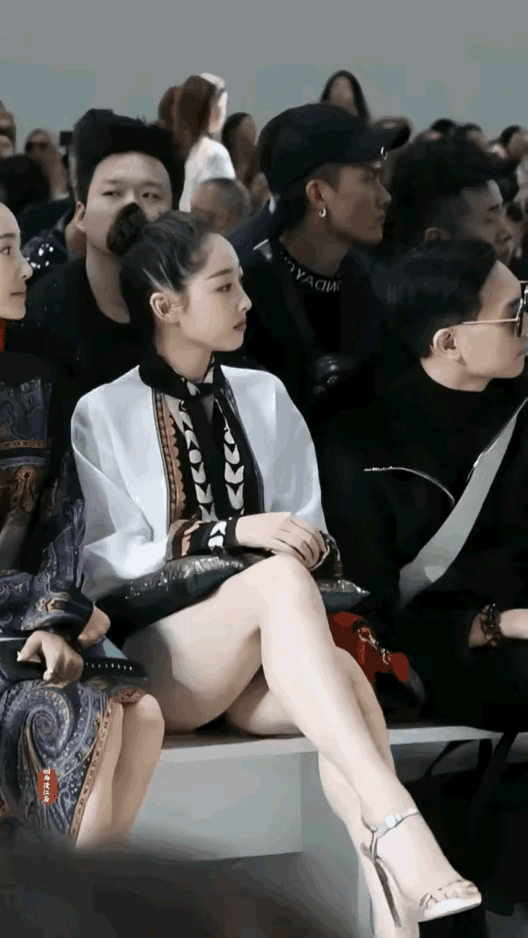 白衣女子上身保守，下身却玩起了裤子消失术，还翘起了二郎腿，虽然她雪白的大腿很吸睛