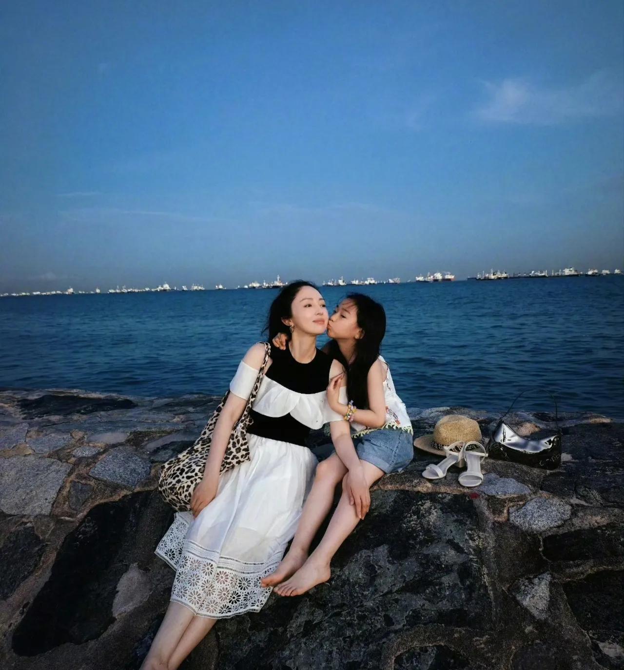 董璇分享一组海边随拍，镜头下的她身处蔚蓝海岸边，发丝被海风轻轻吹动，标志性的小酒