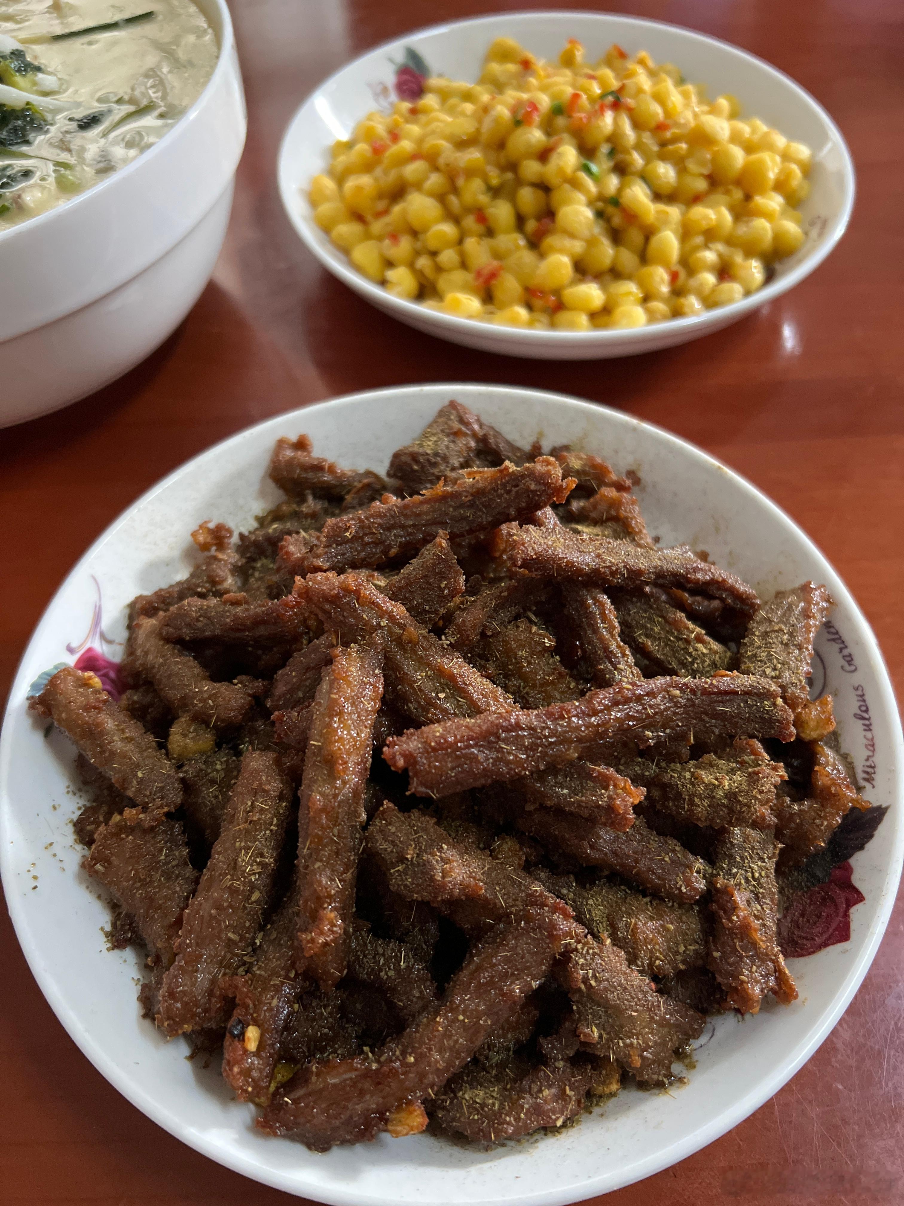 晚餐孜然牛肉，包子，酒鬼玉米，酸笋鱼汤，大乌苏